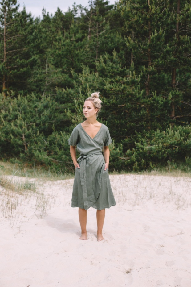 A woman wearing dark green linen wrap dress