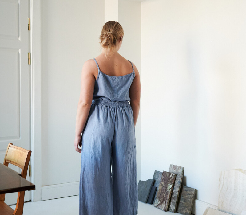 The back of a model wearing wide leg blue linen trousers