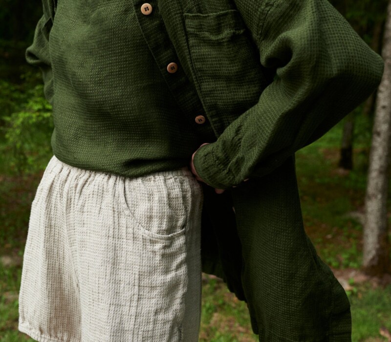 Woman wearing an oversized green waffle linen shirt with a matching linen top and natural grey linen shorts