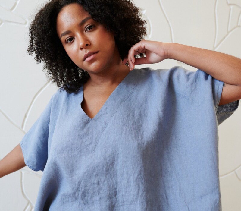 Model wearing a loose-fitting linen top with a V neckline