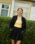 Model wearing black linen shorts, yellow gingham linen top and black linen shirt
