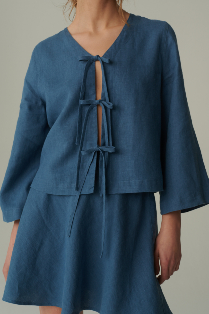 model is wearing tie front linen top in stellar blue color