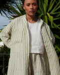Woman in a lightweight oversized linen shirt with matching linen olive stripes shorts