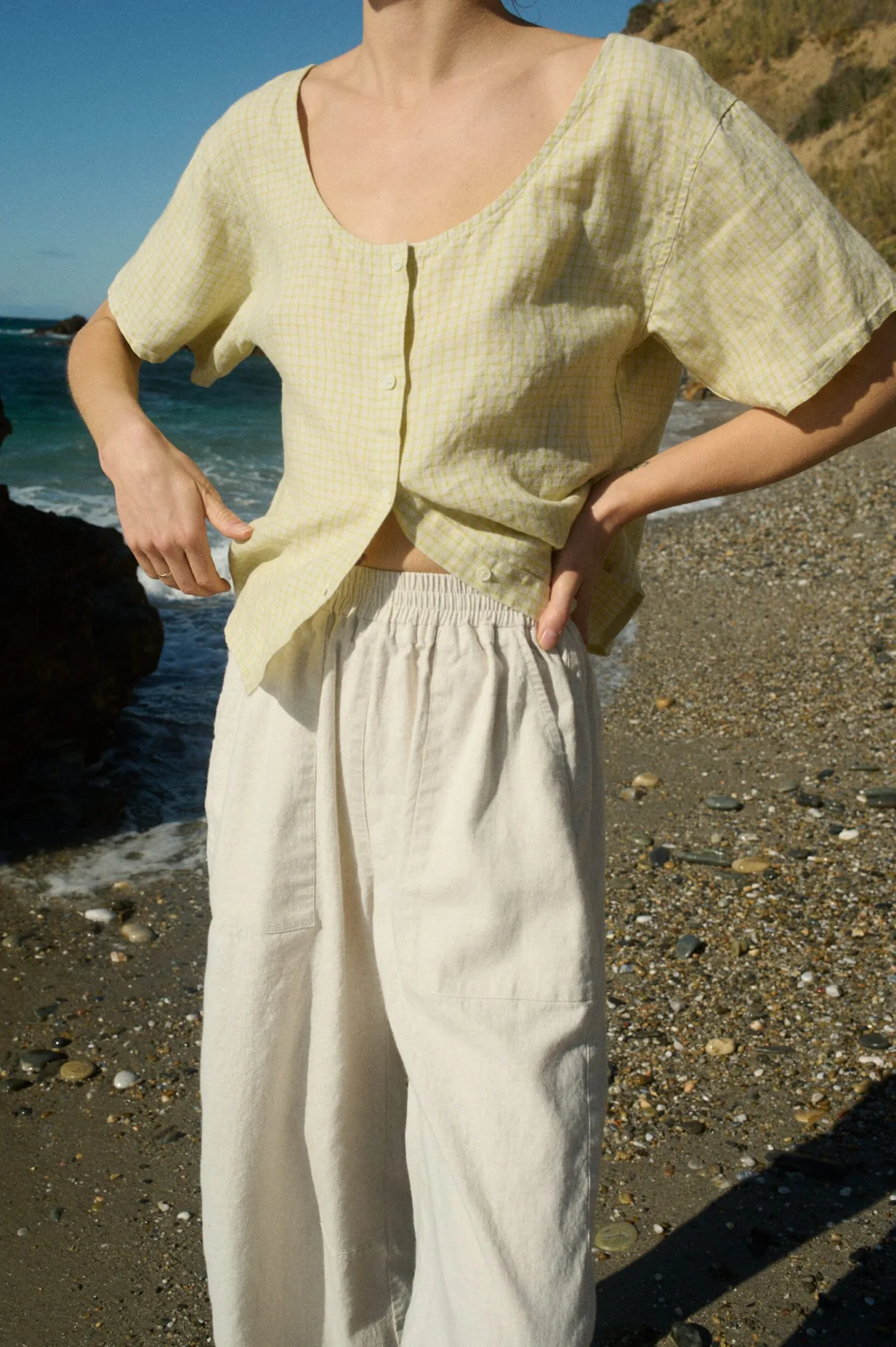 A soft apple checks linen top with a delicate grid pattern and button-down front, paired with off-white wide-leg cotton pants featuring an elastic waistband