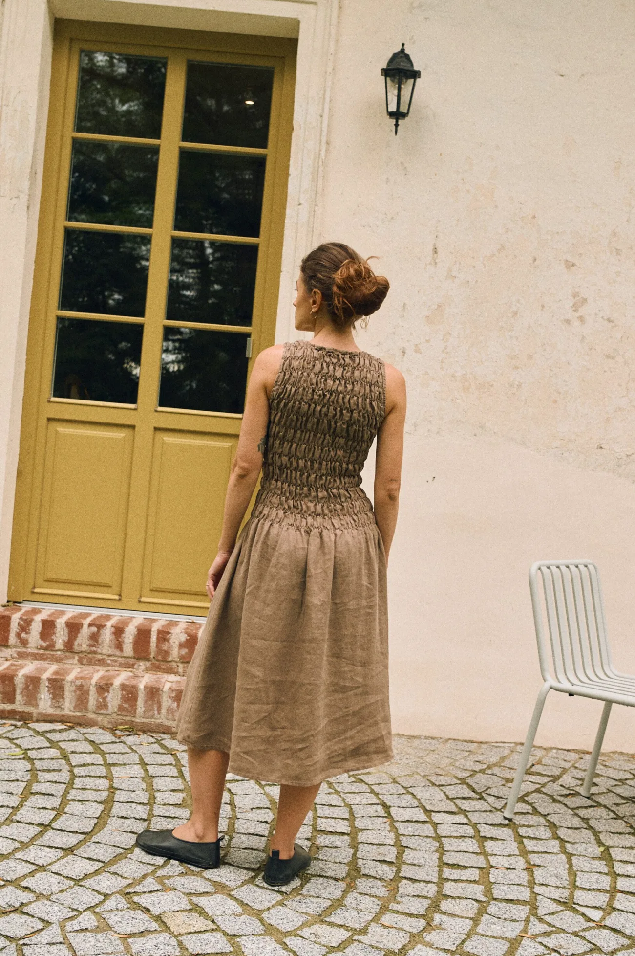 Back view of cacao linen midi dress with smocked bodice and relaxed fit