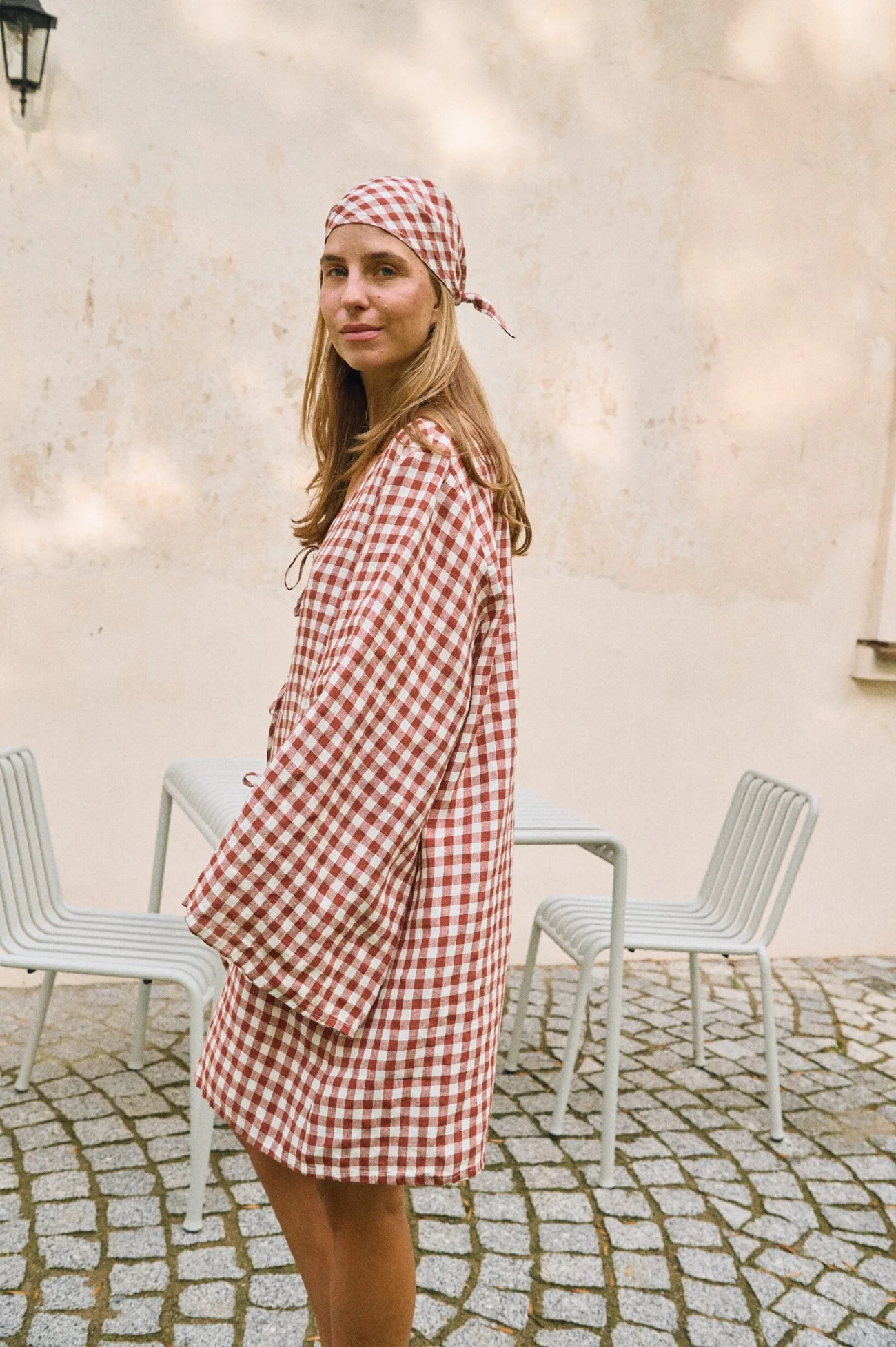 Side profile of terracotta gingham linen dress showing loose fit and airy drape