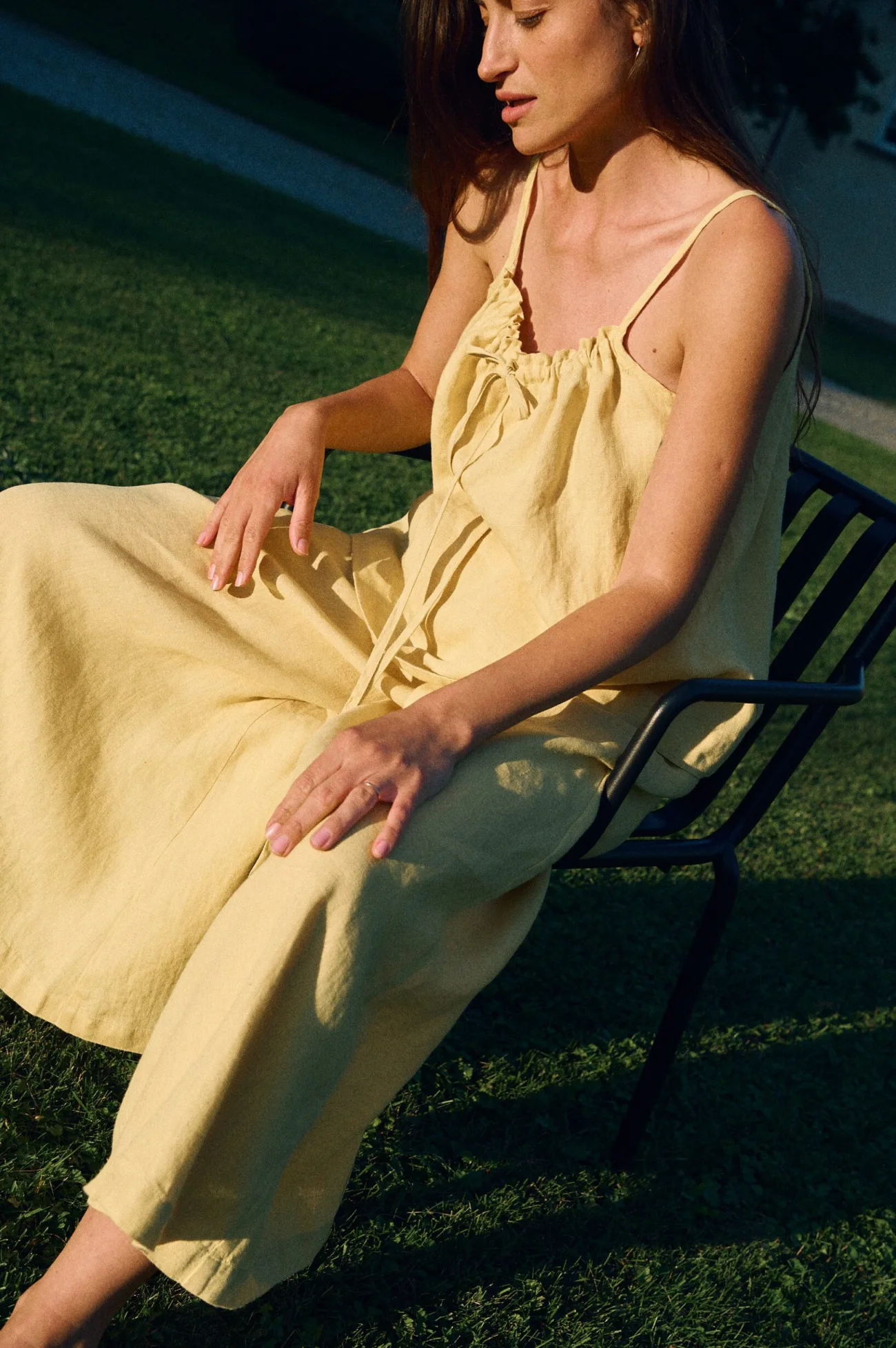 Detail view of yellow linen camisole top with adjustable drawstring front and thin straps