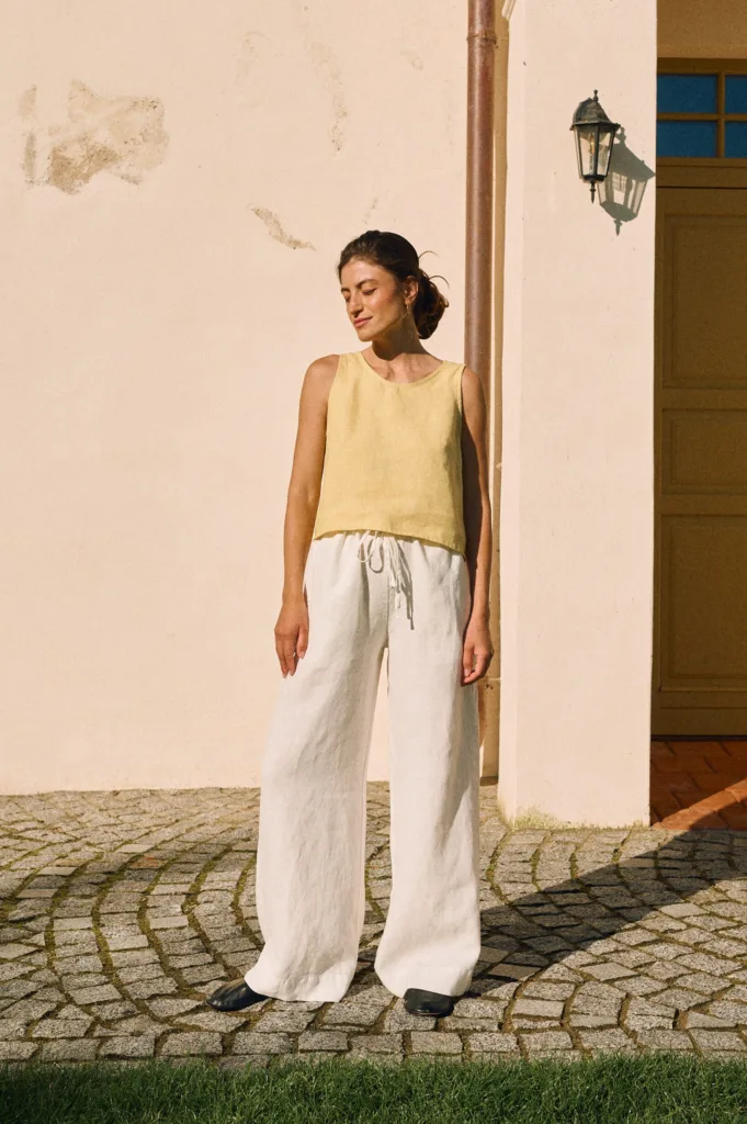 Sleeveless butter yellow linen top paired with white wide-leg linen trousers with a drawstring waist