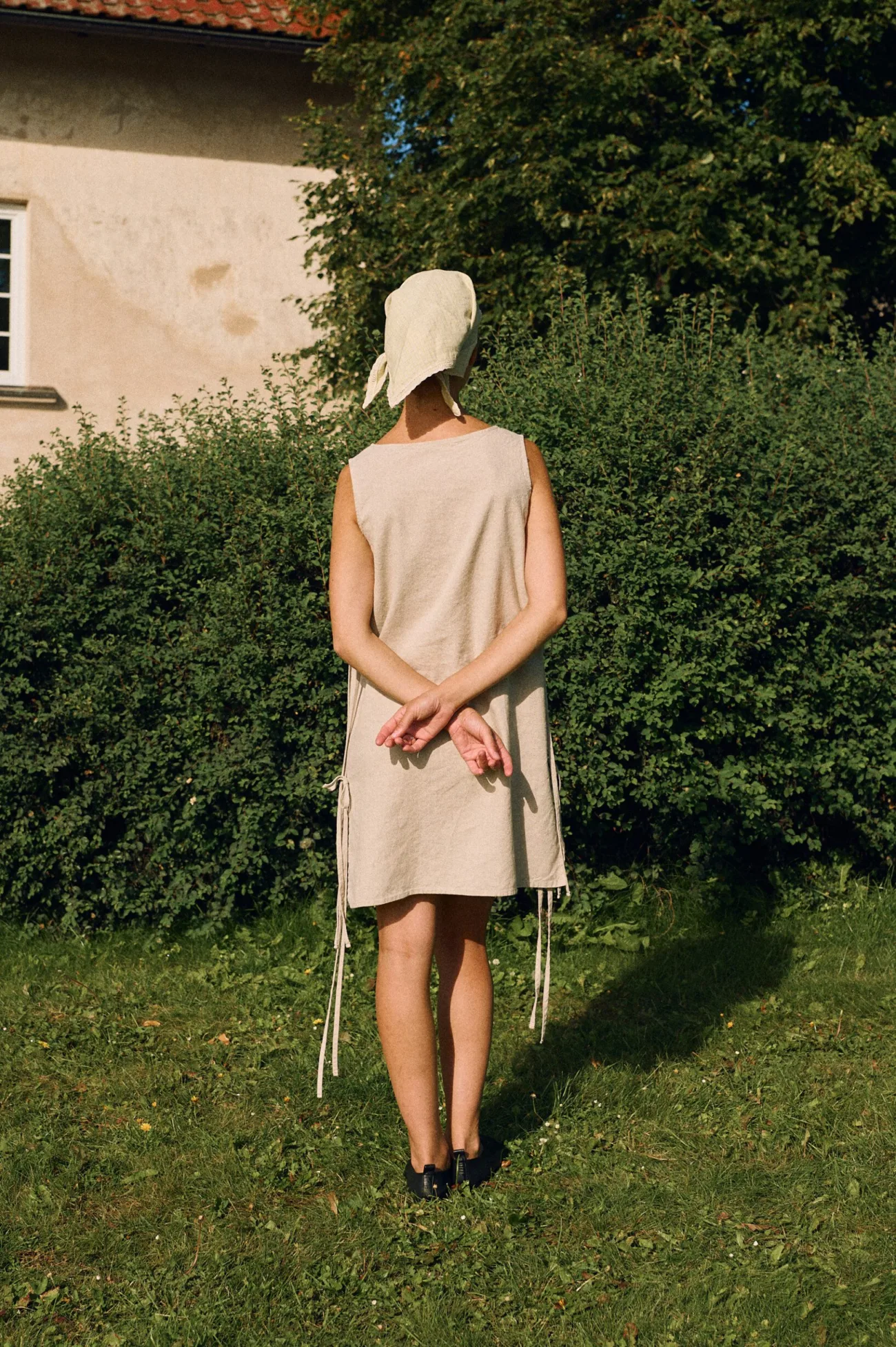Back view of sleeveless natural cotton blend dress with side tie details, minimalist summer dress