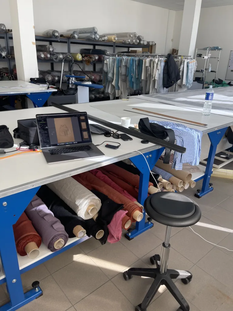 Linenfox linen clothing design studio with fabric rolls, cutting tables and garment pattern rack