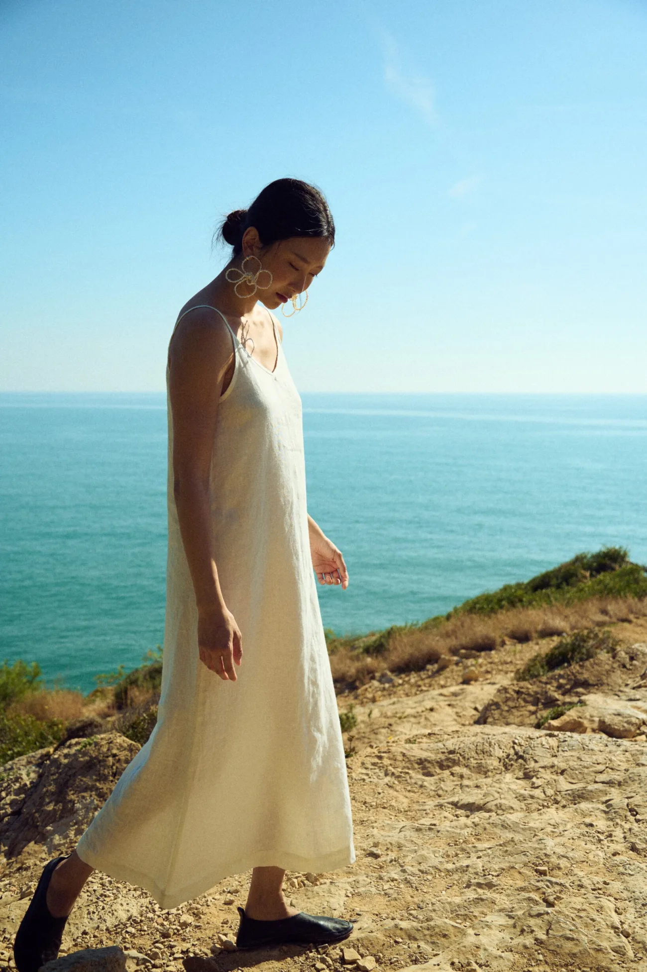 Minimalist white linen slip dress with clean lines and lightweight natural fabric