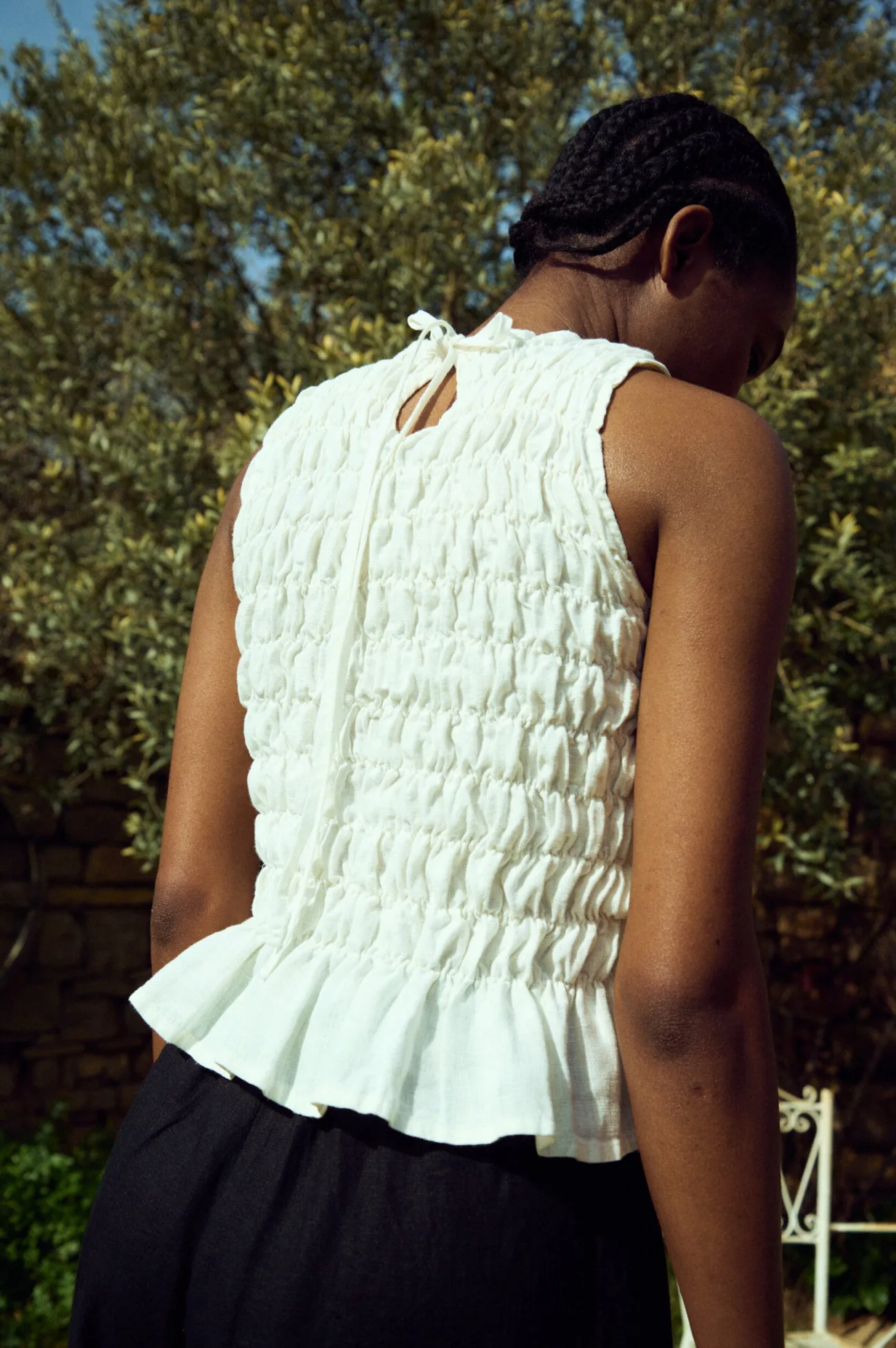 Milky white linen smocked top with gathered texture and tie-back closure