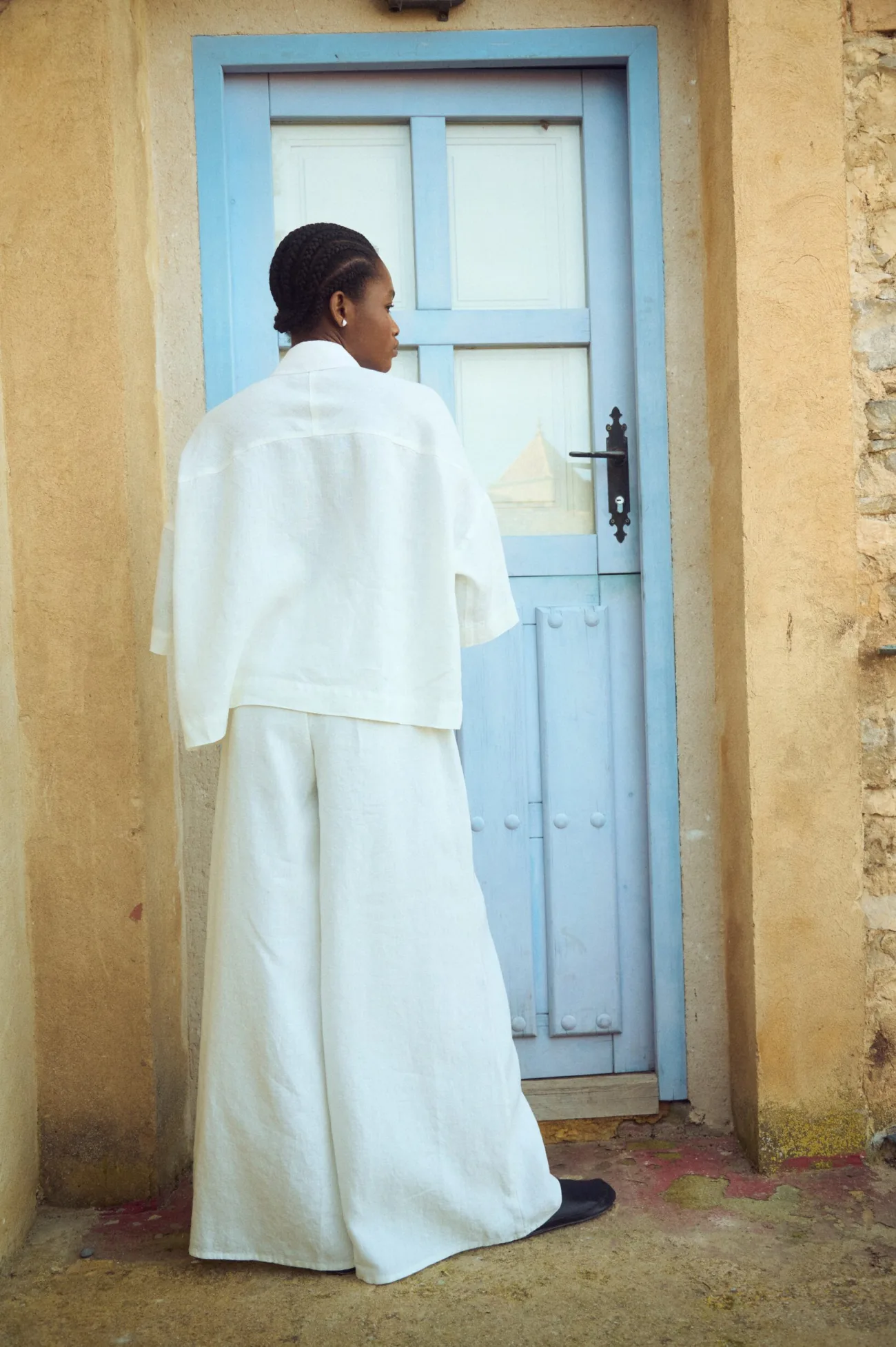 The back view of white linen culottes with matching oversized linen shirt