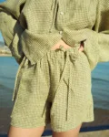 Green mini gingham linen shorts with elasticated waistband and decorative ties, paired with a matching top