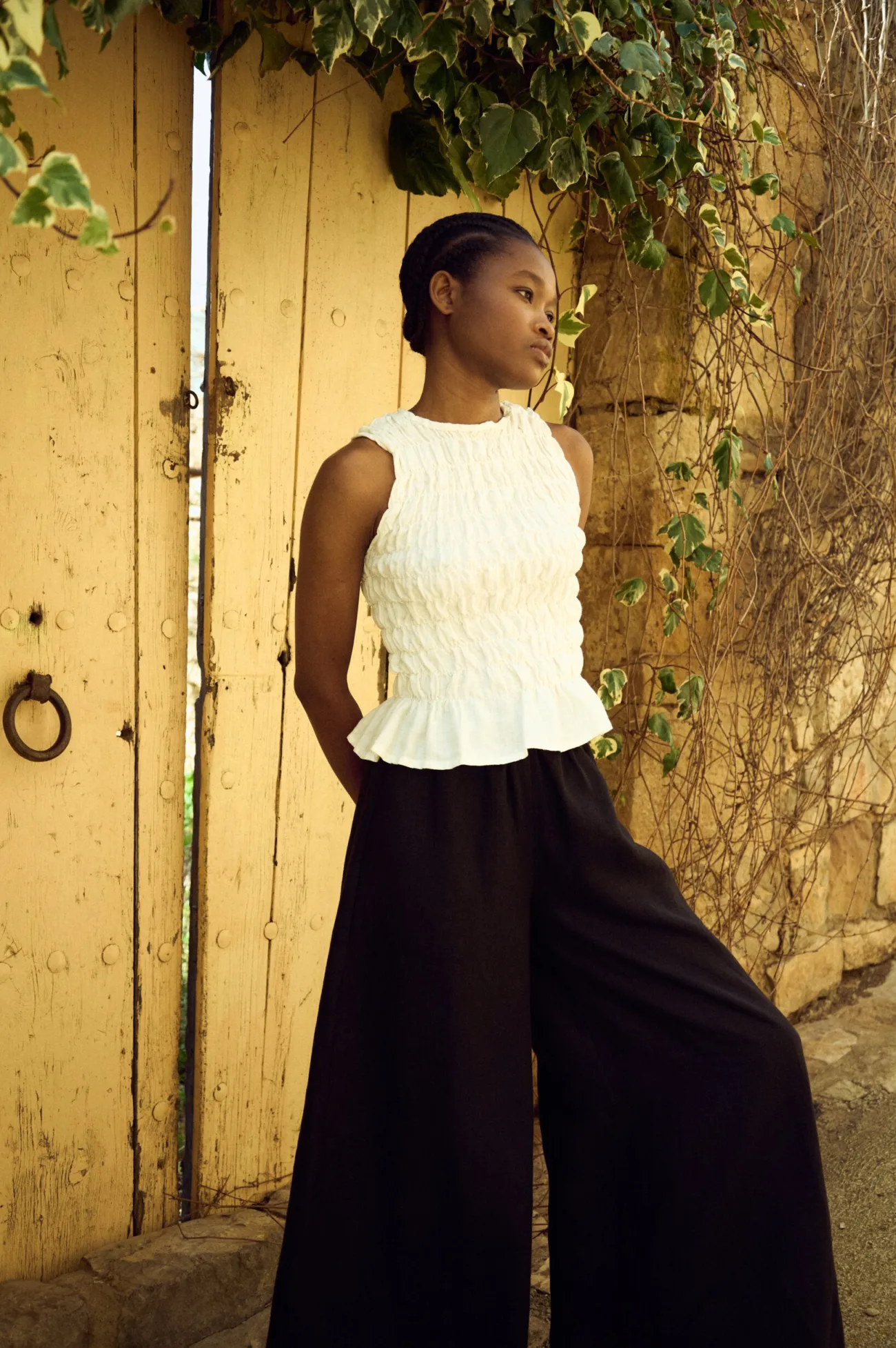 model wearing white smocked tank top and black linen culottes