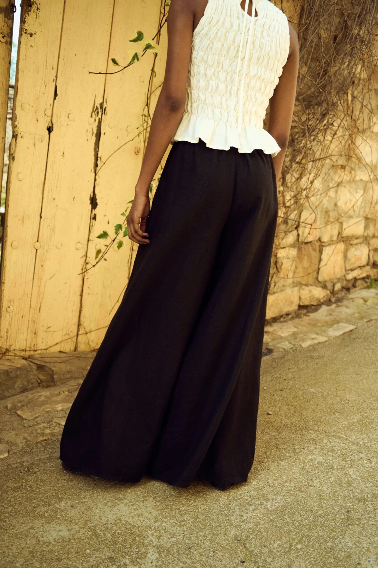 the back view of black linen culottes and white smocked linen top