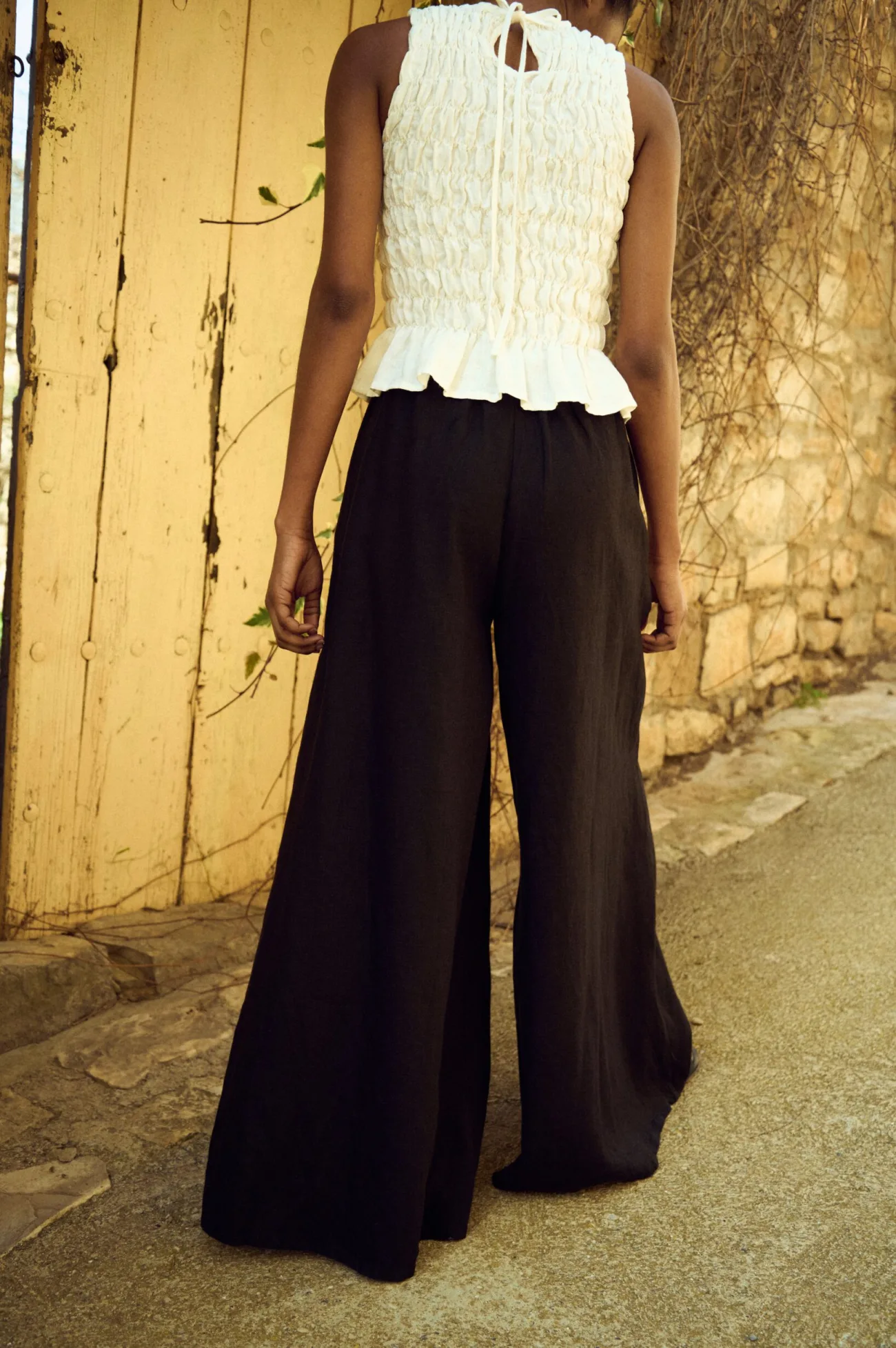the back of black linen culottes and white smocked top