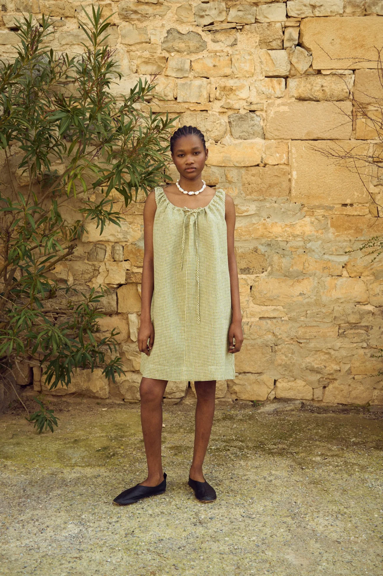 Sleeveless green gingham linen mini dress with soft gathering at the neckline and loose silhouette