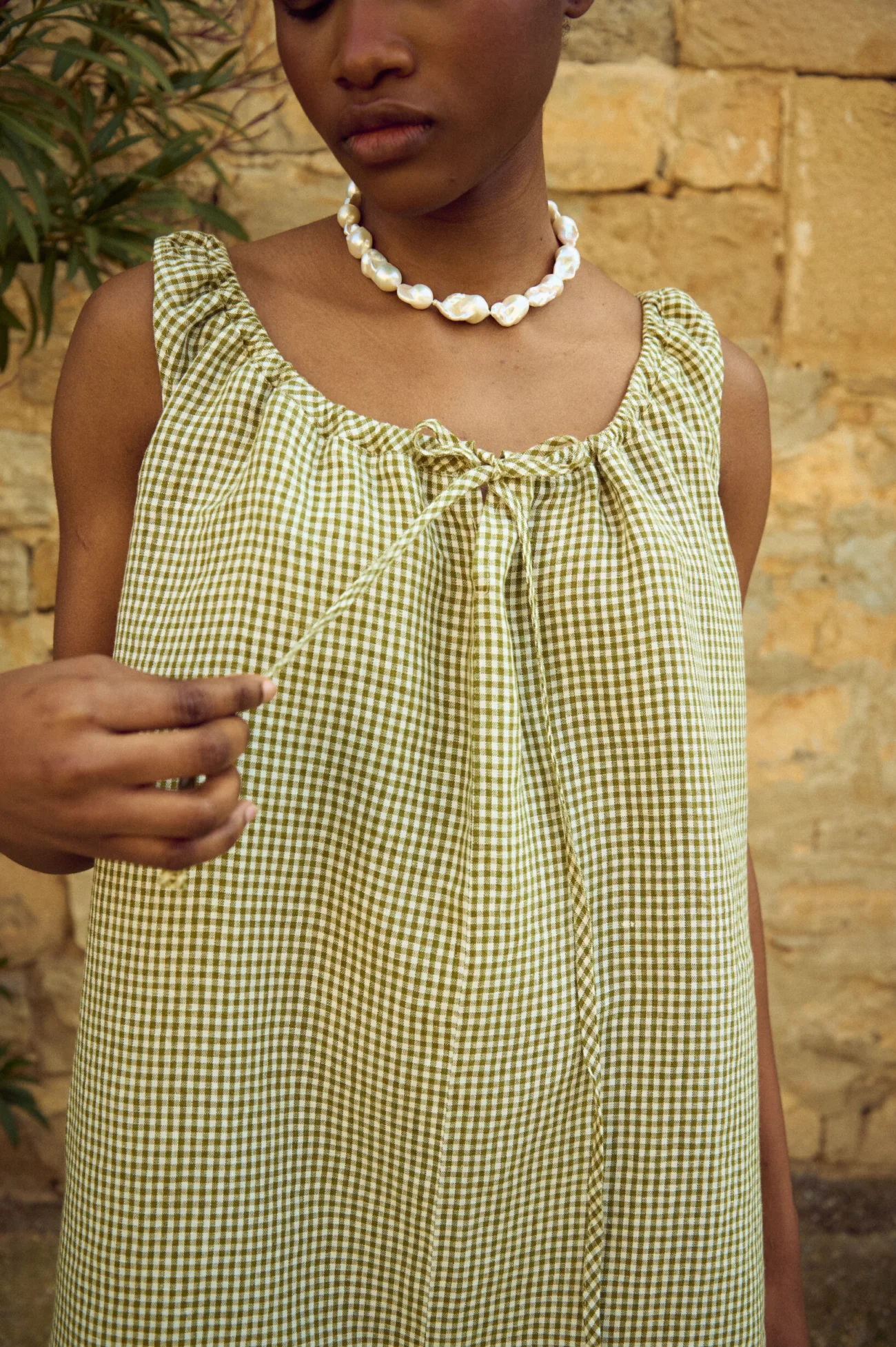 Green mini gingham linen dress featuring softly gathered neckline with drawstring tie