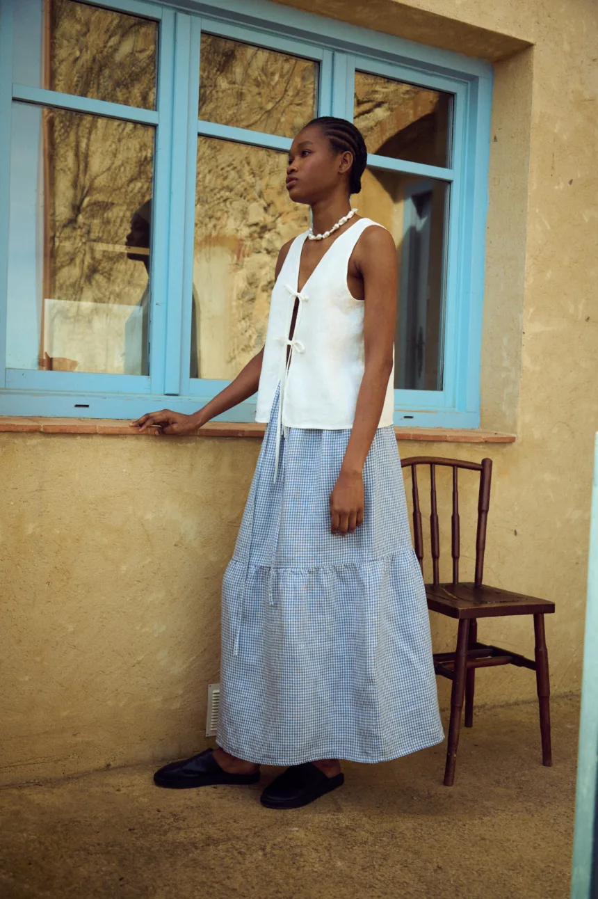 Blue gingham linen skirt with a gathered tier and soft volume, paired with a white linen top