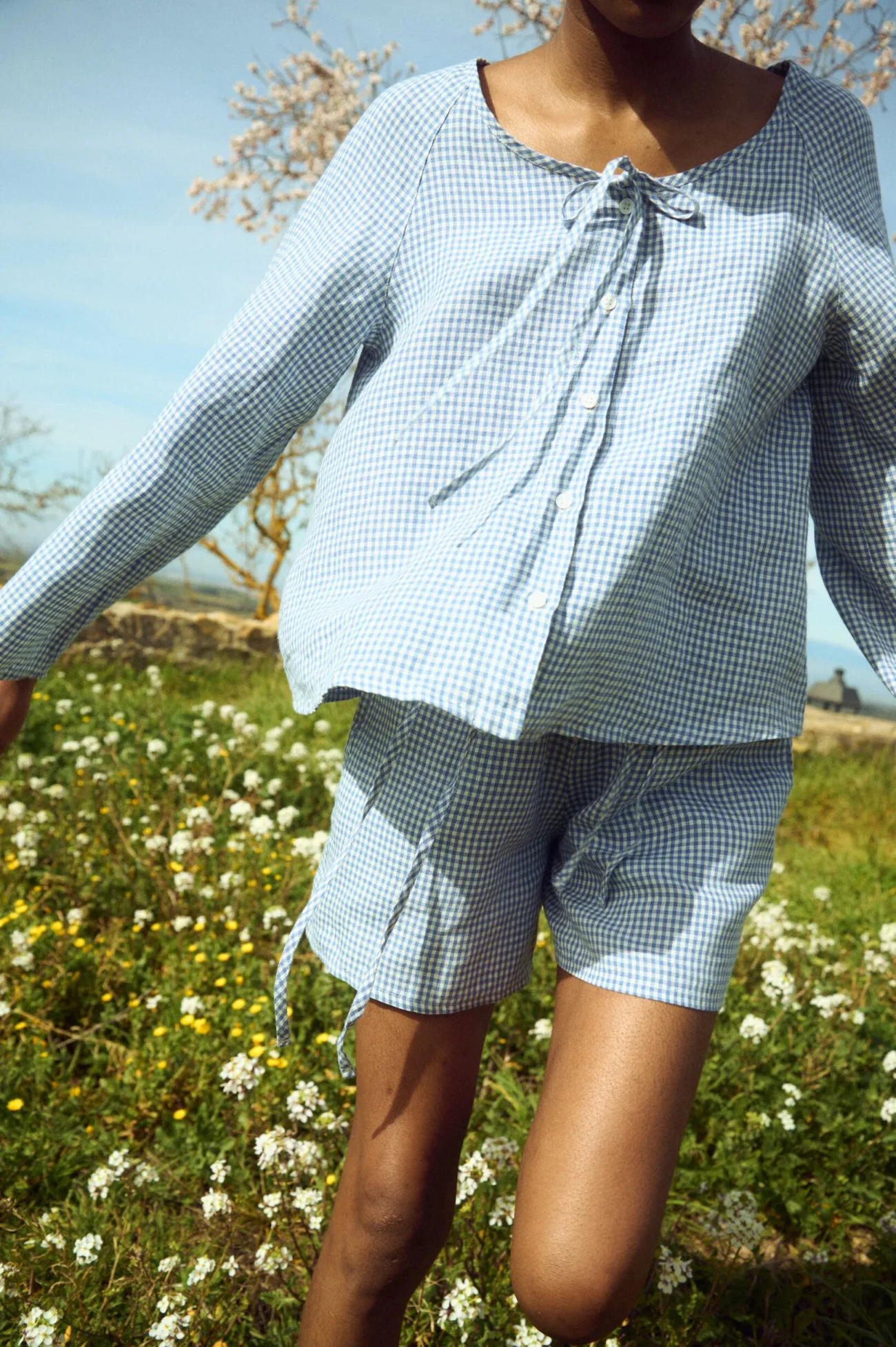 Blue gingham linen top with clean shell button front and relaxed sleeves, paired with coordinating shorts