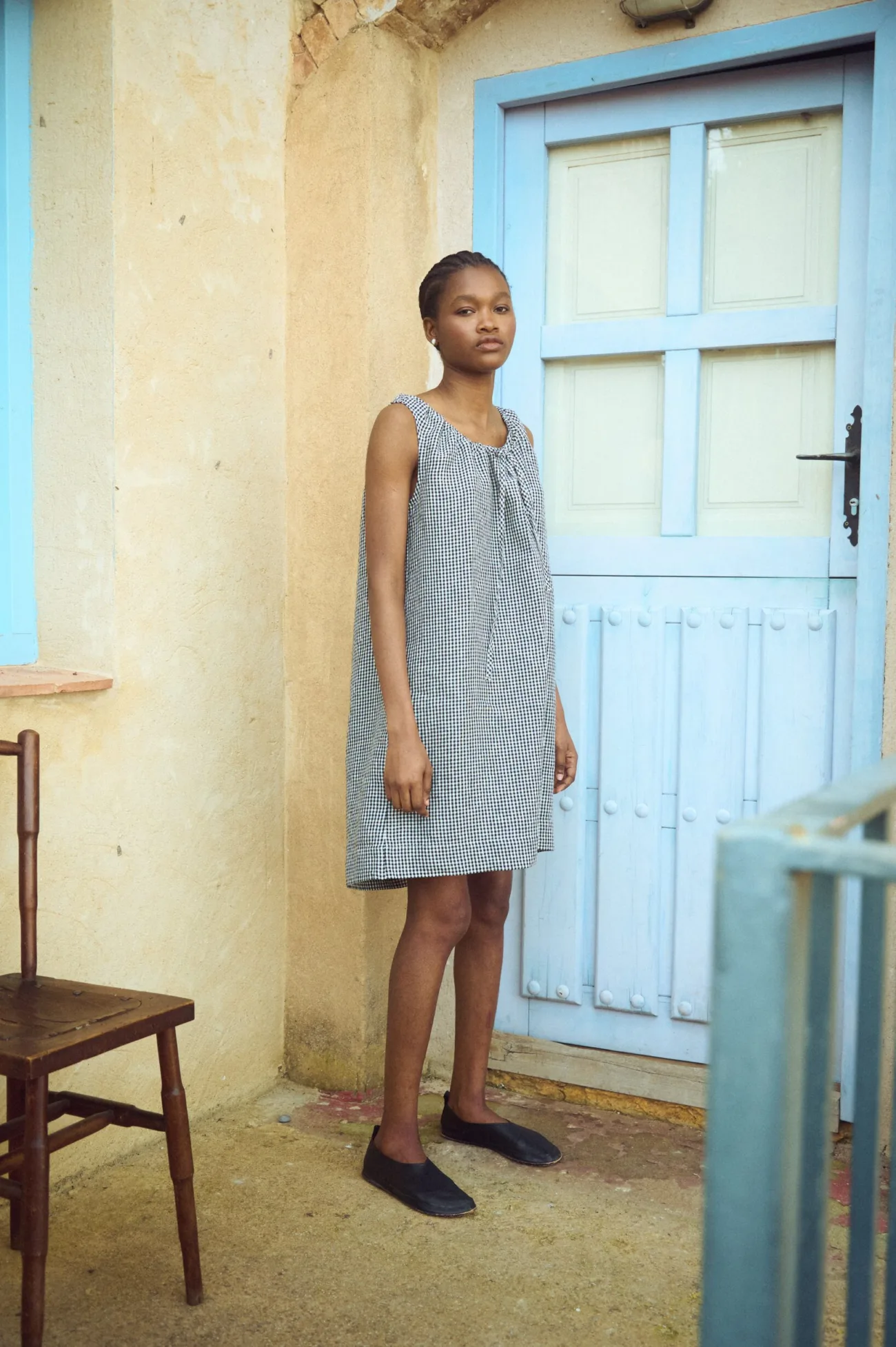 Black gingham linen dress with gentle neckline gathering and long tie cords, designed for an easy fit