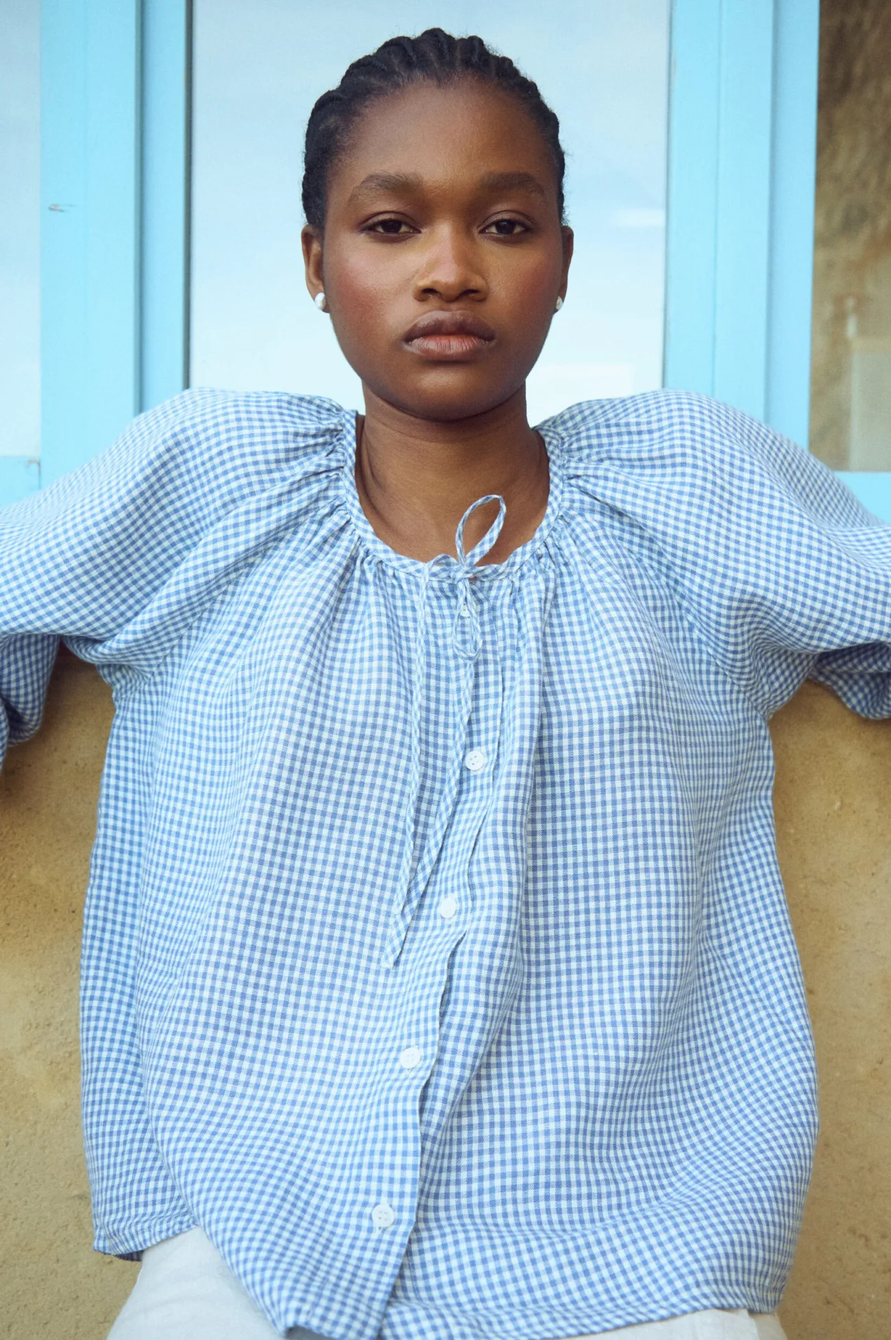 Blue mini gingham linen top featuring a softly gathered neckline and shell button fastening