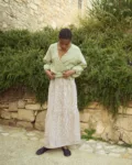 Brown gingham linen long skirt featuring a softly gathered lower panel and fluid drape, styled with a lightweight wrap blouse