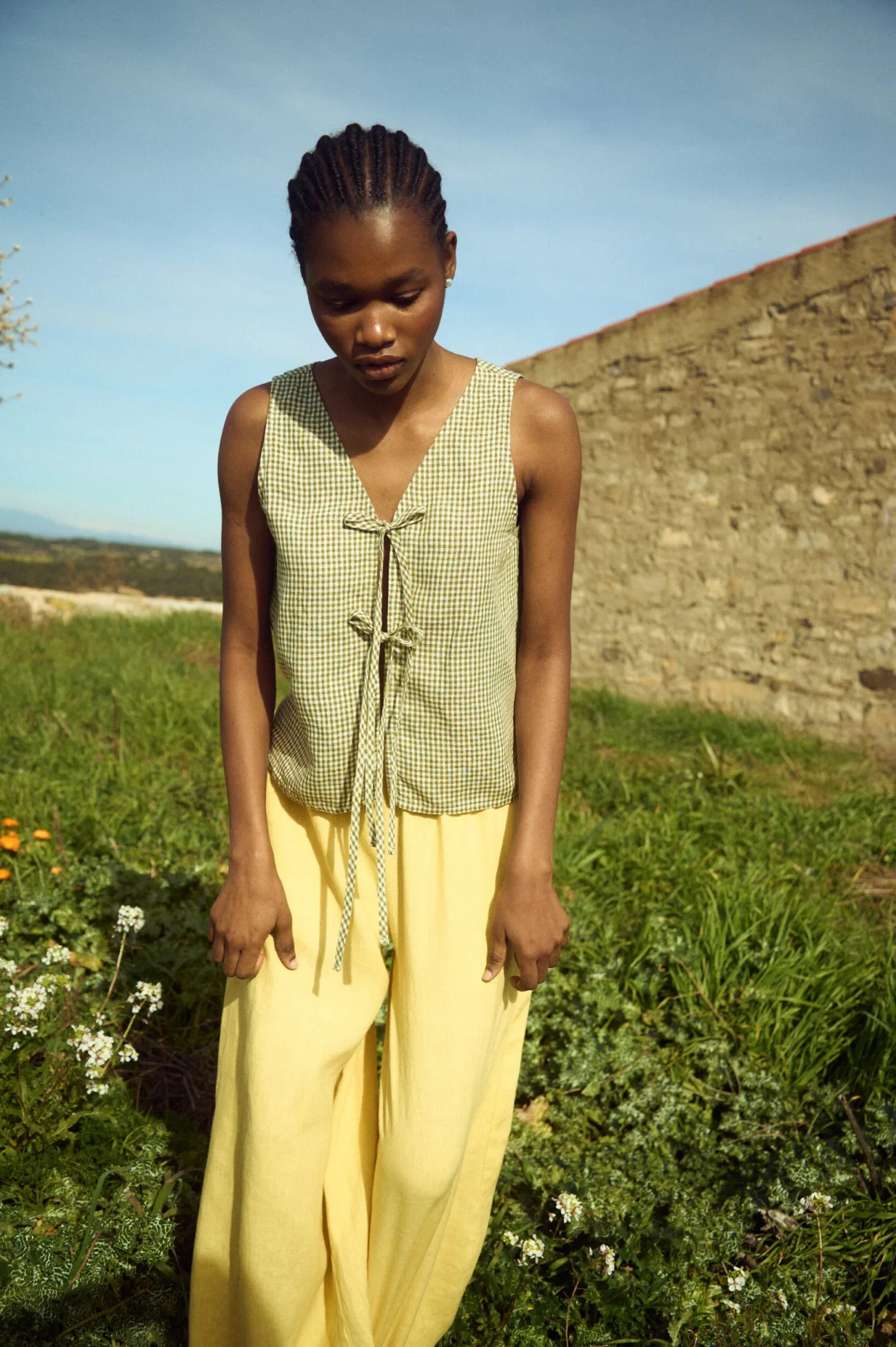 Green gingham linen sleeveless top with front tie closure paired with butter yellow linen pants