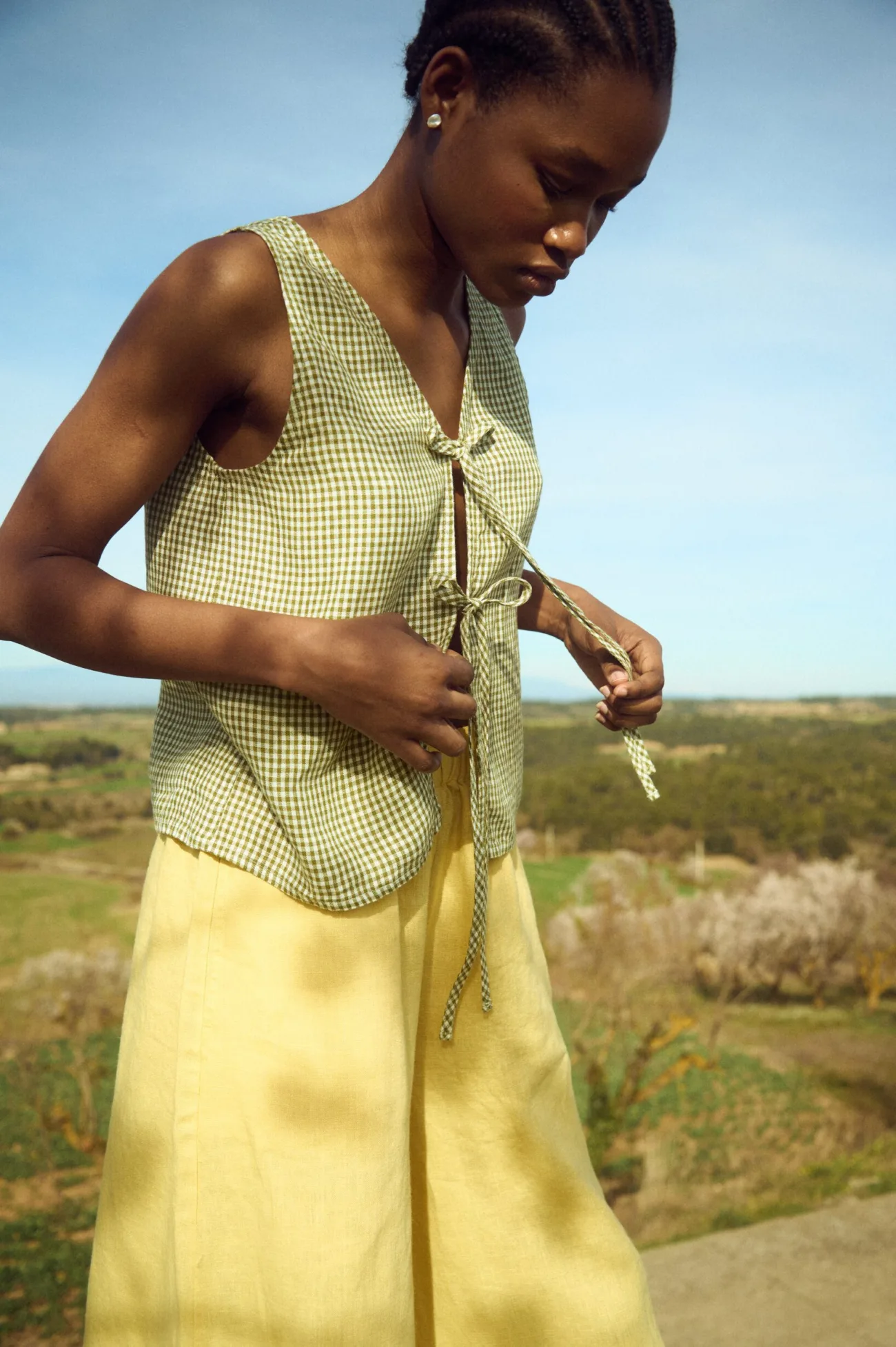 Sleeveless green mini gingham linen top with tie-front detail styled with butter yellow linen pants