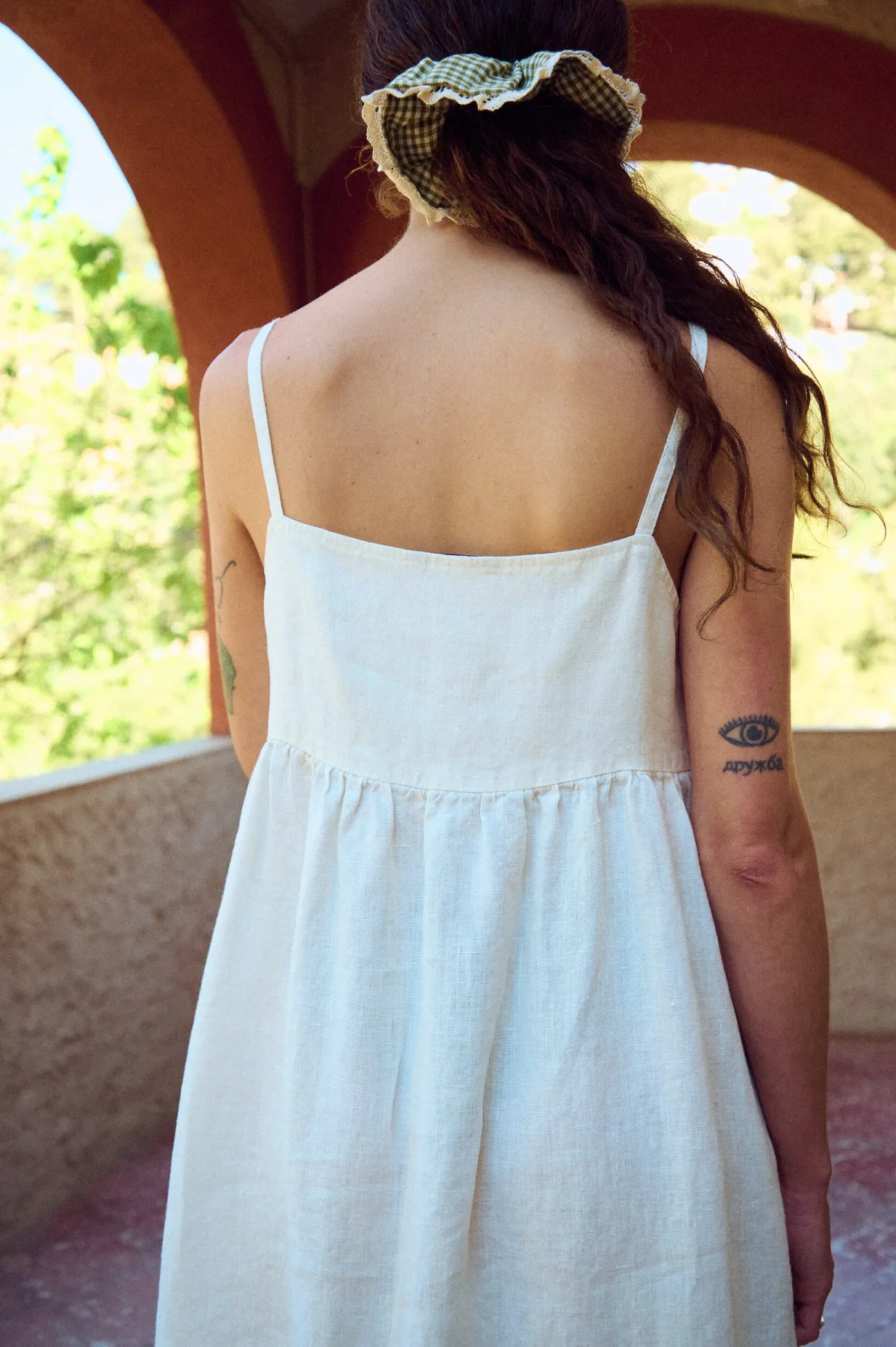 the back of white linen summer dress with thin straps