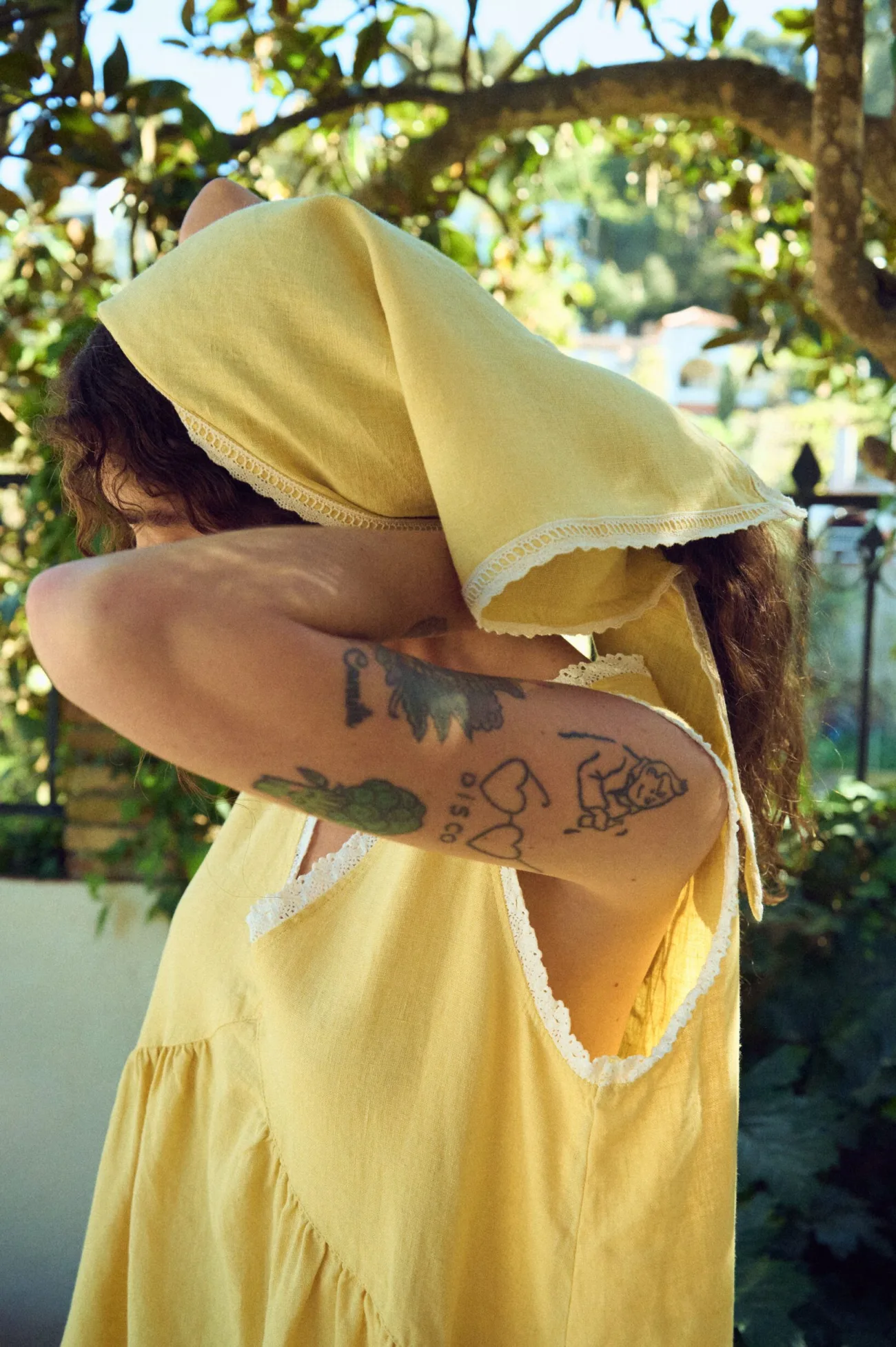 woman wearing butter yellow linen head scarf with lace trim edges