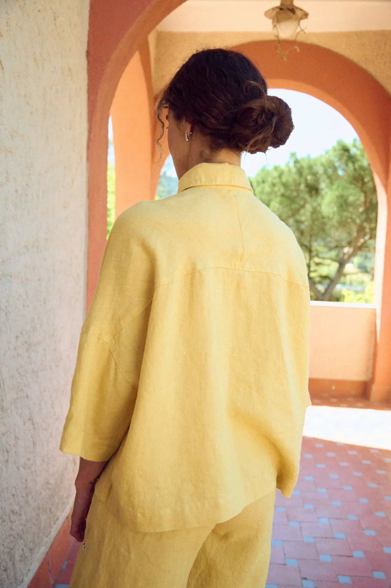 the back of oversized linen shirt in butter yellow and dropped shoulders