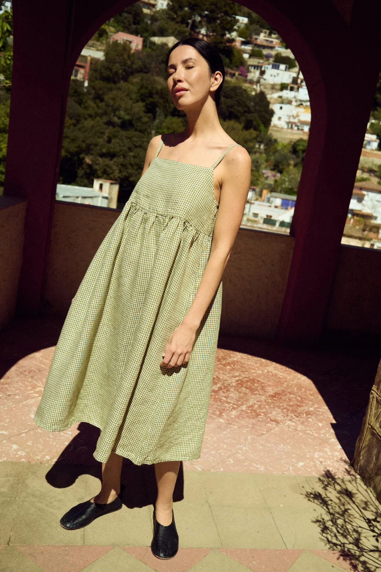 woman wearing green gingham midi summer dress with spaghetti straps and pockets