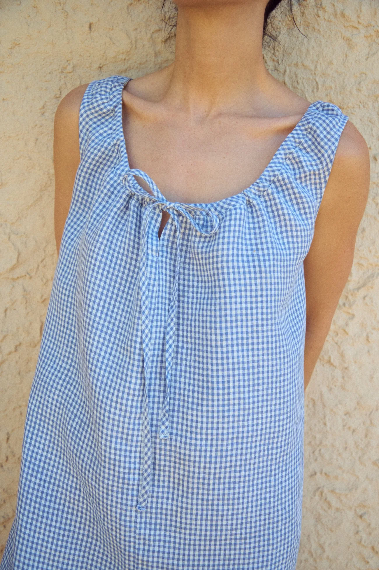 close-up of mini gingham linen dress in blue and white with drawstring adjustable neckline