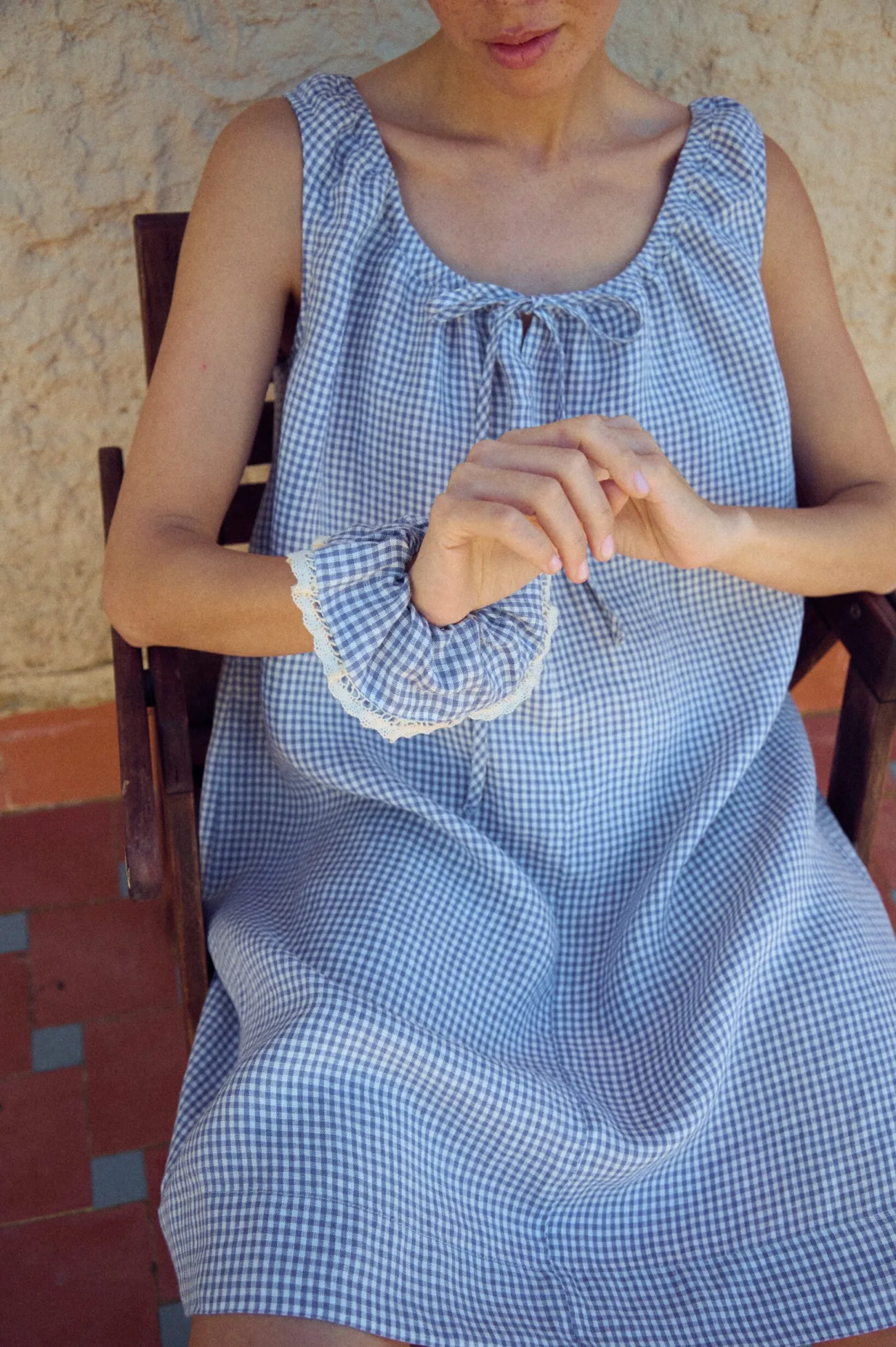 close-up of loose fit blue mini gingham linen dress with matching scrunchie with lace trim