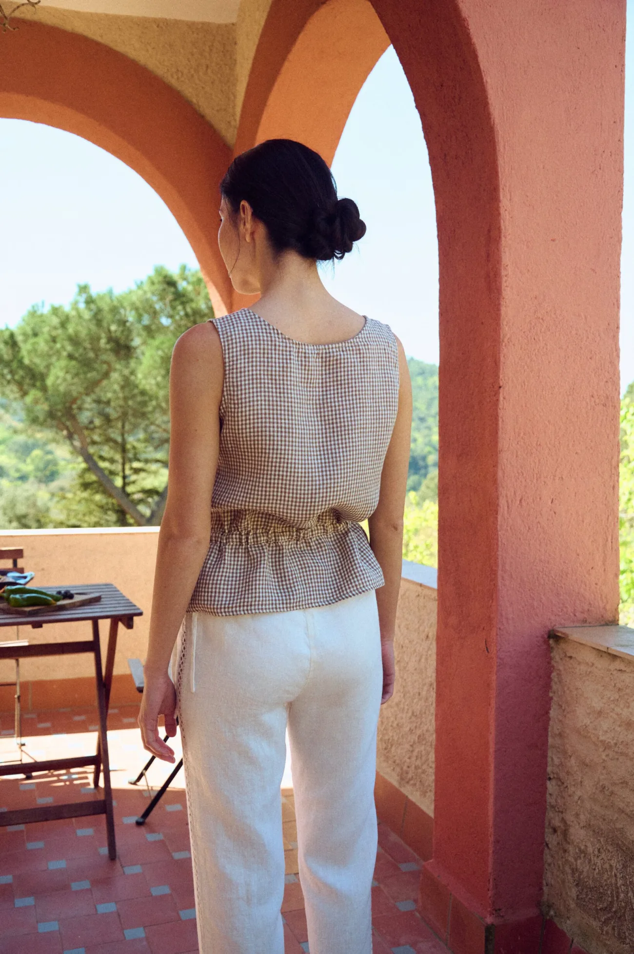 the back of peplum summer top with no sleeves in brown gingham linen