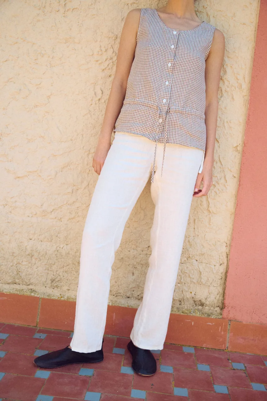white straight cut linen trousers with lace details and drawstring waist paired with brown gingham top