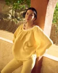 woman is wearing oversized linen blouse in butter yellow color