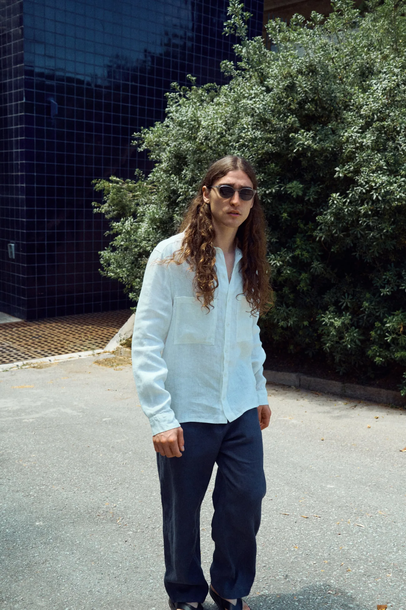 Men’s graphite grey linen trousers cut in an easy, loose silhouette, paired with a milky white linen shirt