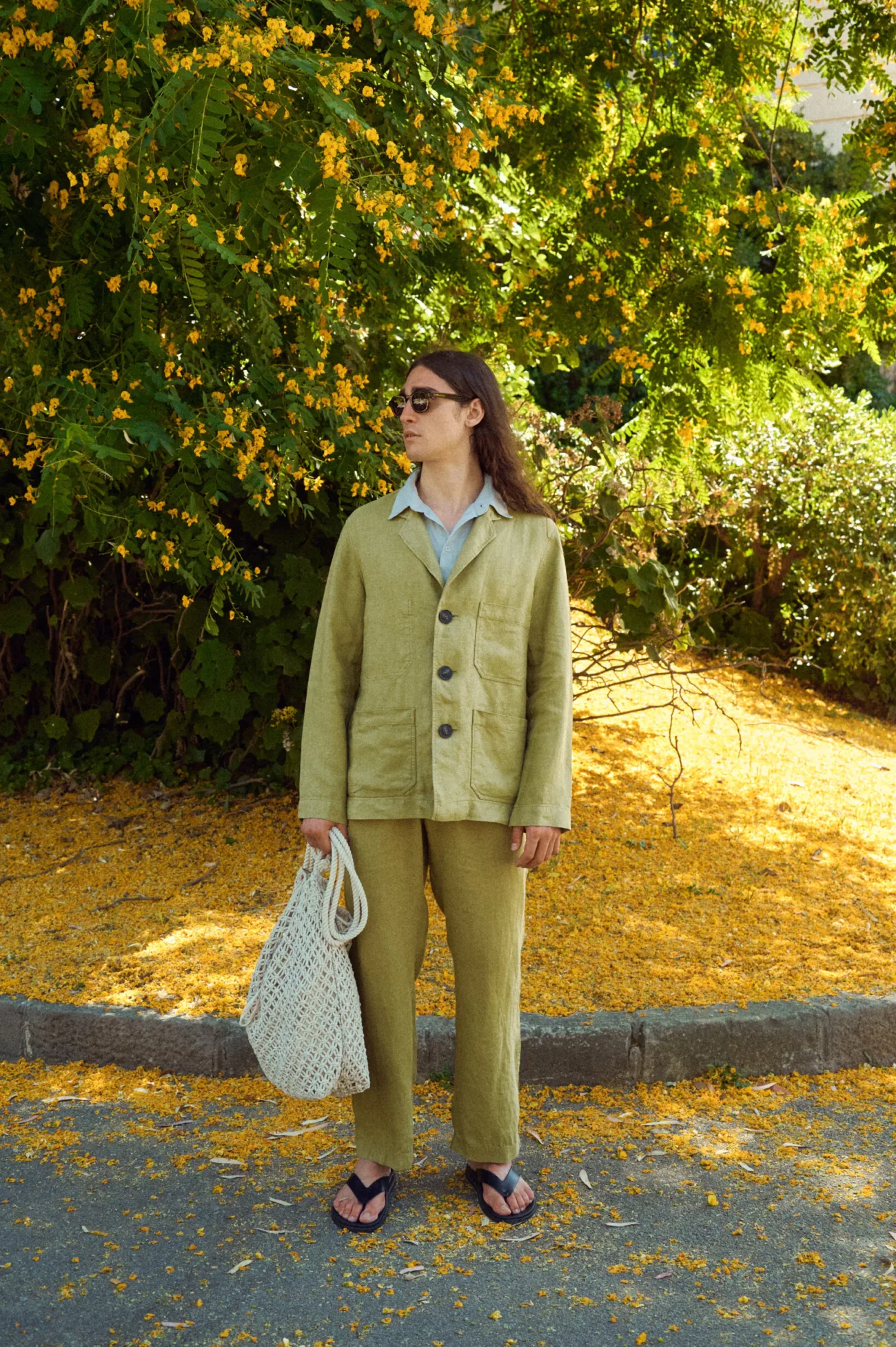 Men’s olive heavy linen jacket with a relaxed tailored cut, classic lapels, dark three-button closure and generous patch pockets, paired with matching olive linen trousers and an ice grey linen shirt