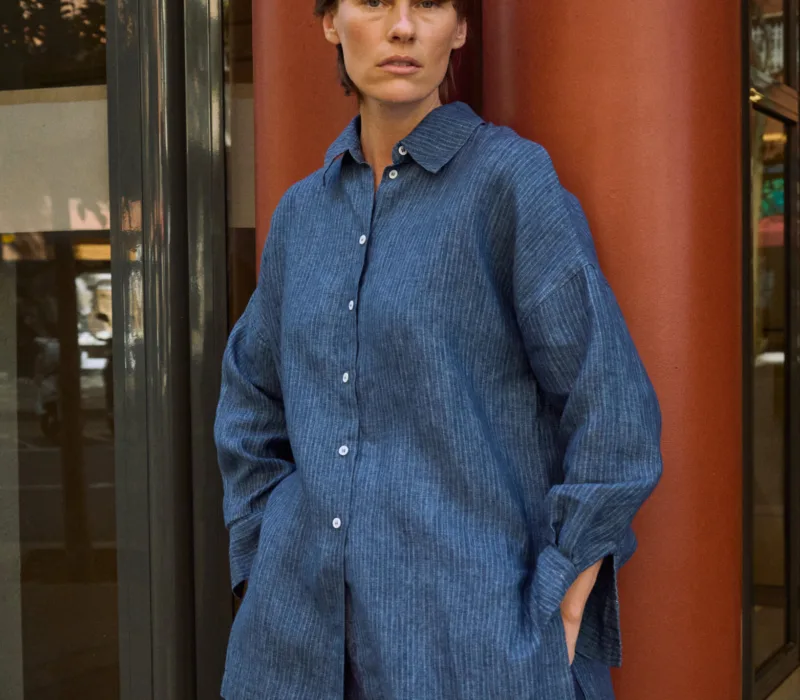 Blue striped linen button-up shirt with a relaxed oversized fit, pointed collar and side slits