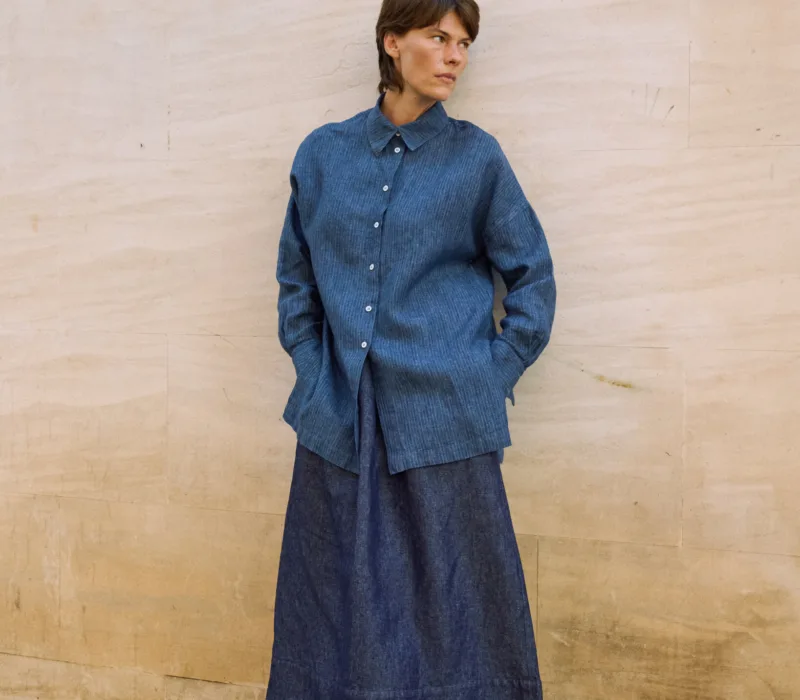 Full-length denim linen maxi skirt with a gently flared shape, paired with an oversized blue striped linen shirt