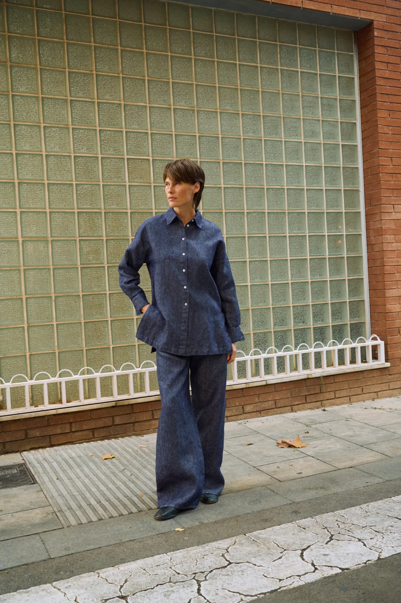 Blue denim linen shirt with button-down front and pointed collar, styled with matching wide-leg linen pants