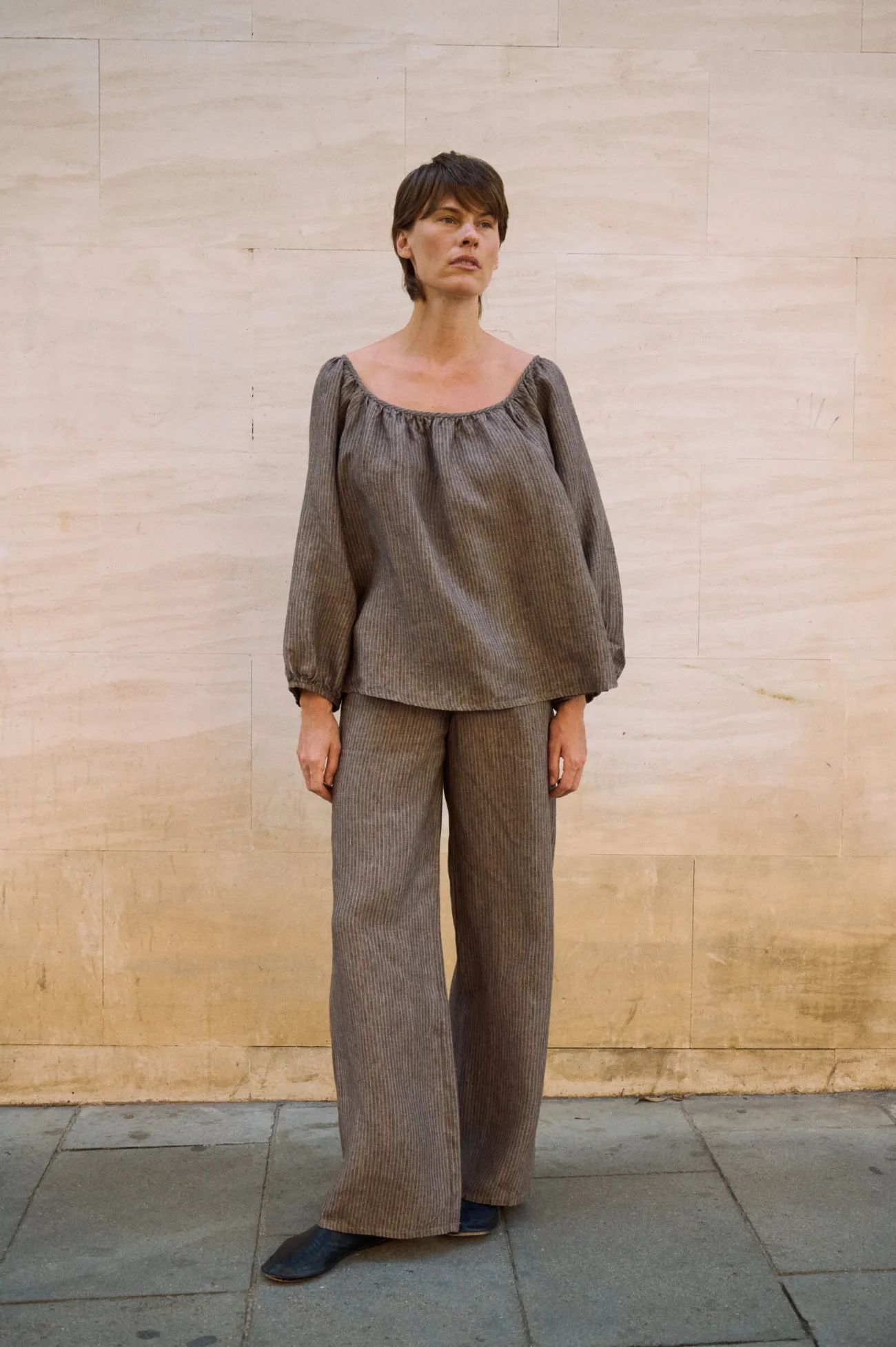 Brown striped linen blouse with a gathered scoop neckline and voluminous sleeves, paired with matching wide-leg linen pants